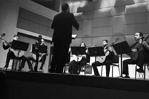 A black and white photo of the Classical Guitar Ensemble performing