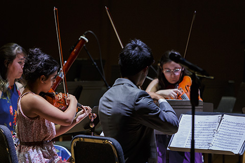 Strings ensemble performing live on stage at an event at the University of Miami